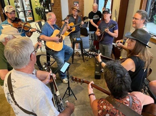 guitar, mandolin, banjo, bass, and fiddle players all playing together in a circle